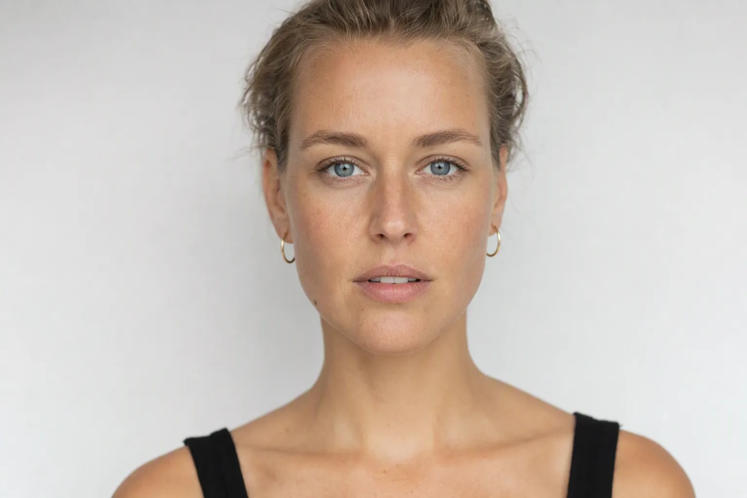 Vrouw recht van voren met het haar naar achteren, gezichtsvorm goed zichtbaar