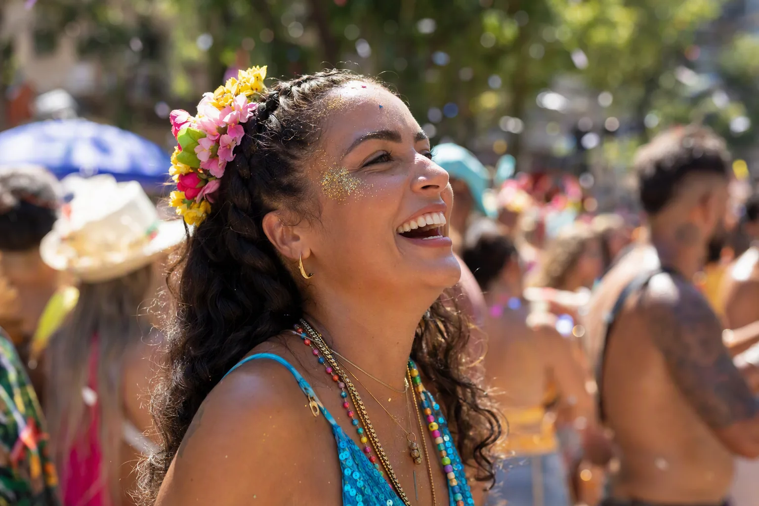 Mulher no bloco de Carnaval com tranças embutidas, coroa de flores e glitter dourado no rosto, ao sol